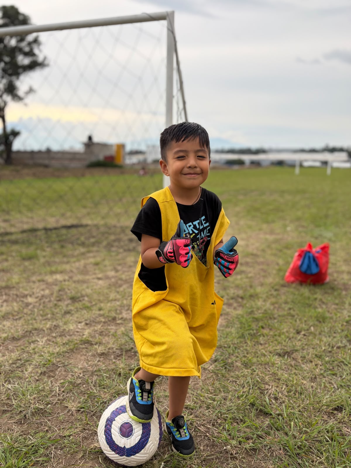 Portero sonriente con guantes listo para entrenar