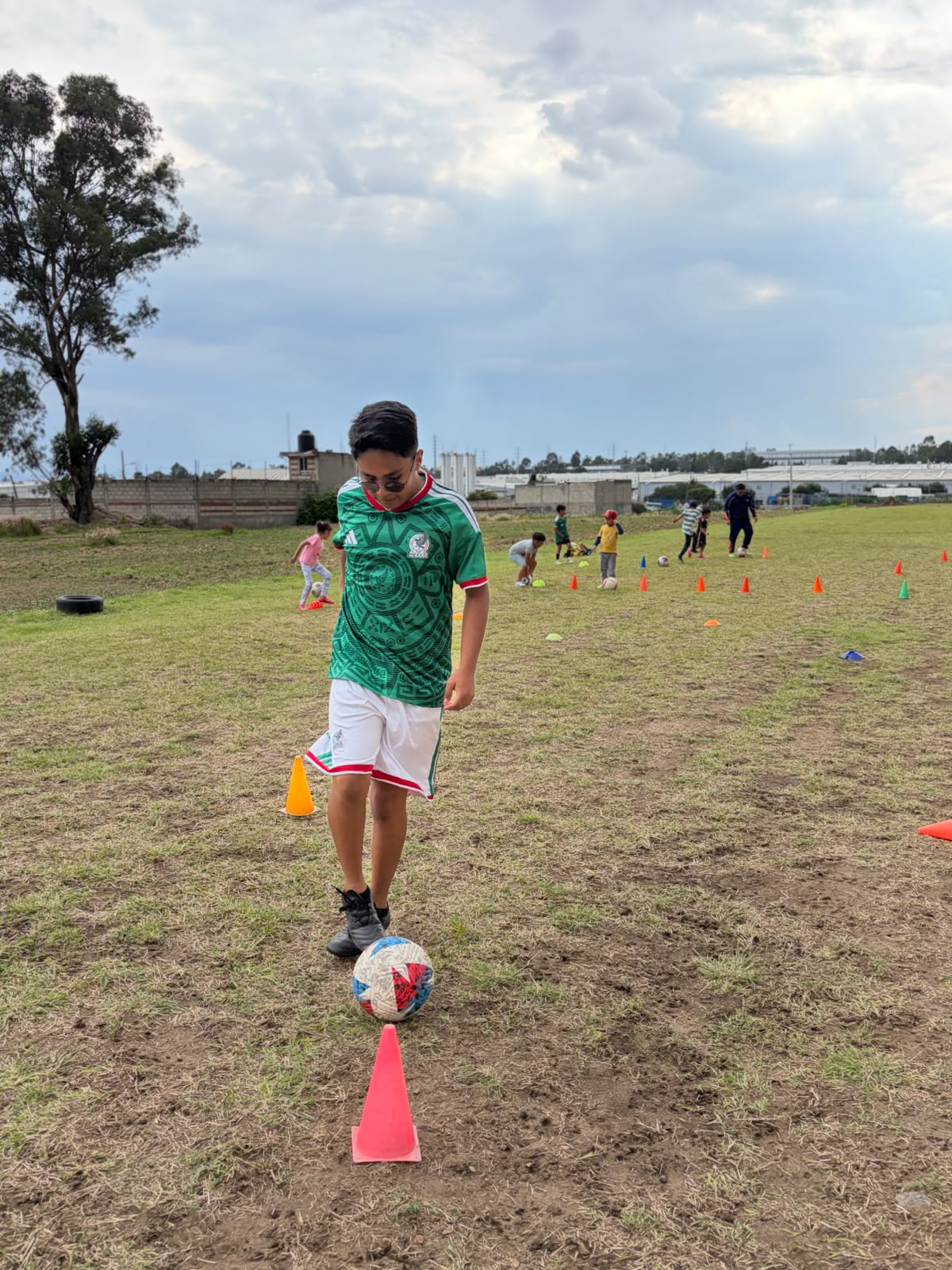 Conducción de balón entre conos en la cancha