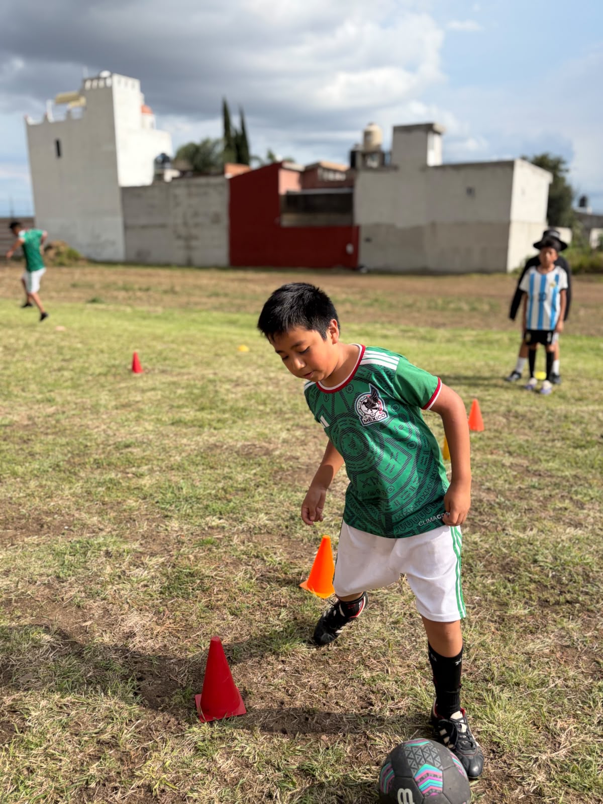 Pequeño prospecto driblando conos con jersey de México